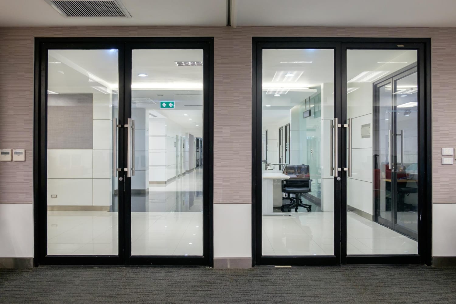 Two pairs of black-framed glass office doors with stainless steel pull handles