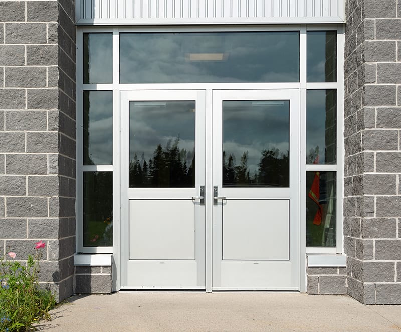 Pair of commercial entry doors with a glass transom and sidelites in a block wall