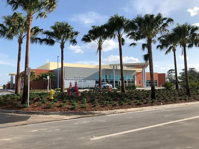 Exterior of the FDOT District Five Regional Transportation Management Center in Sanford, Florida, a one-story building behind a row of palm trees