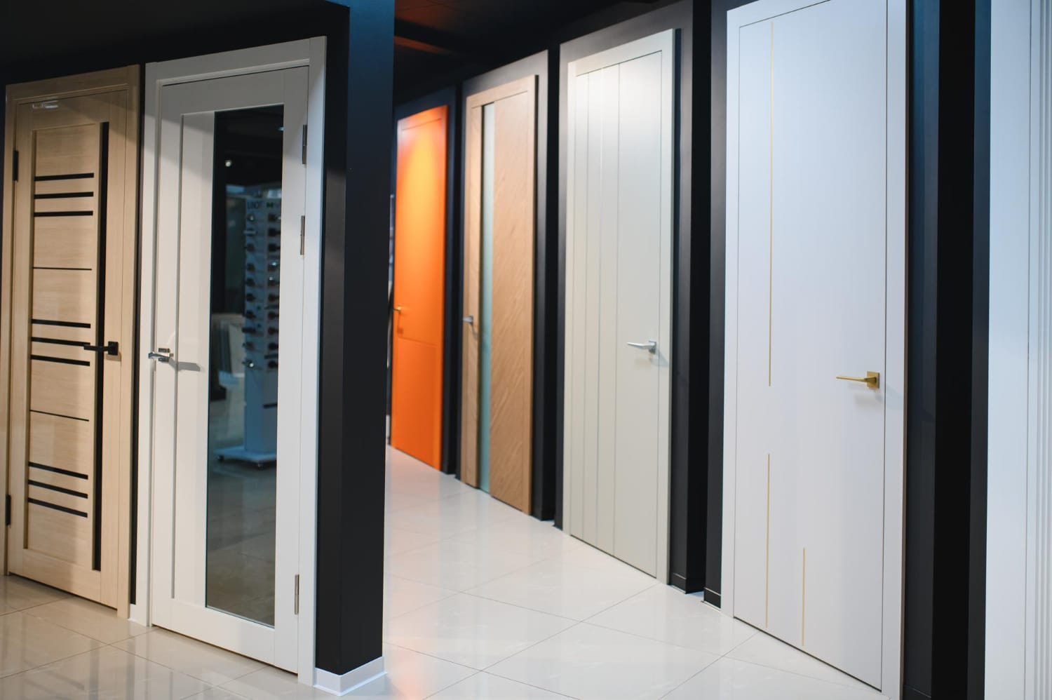 Showroom display of commercial interior doors in wood, white, and orange finishes