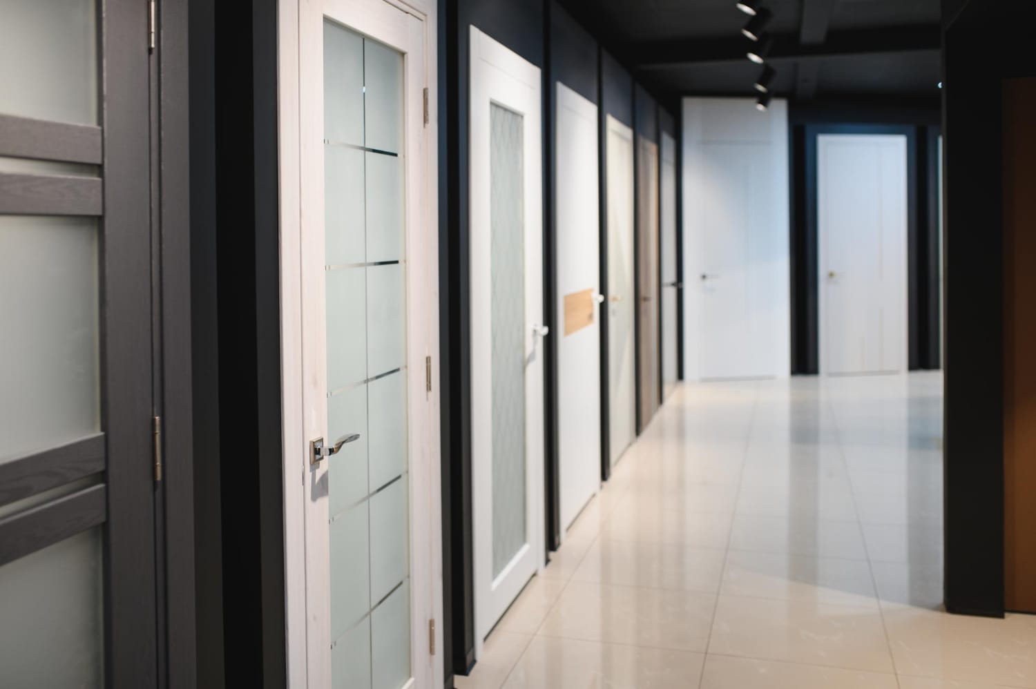 Showroom corridor lined with white and wood-finish doors with frosted glass panels